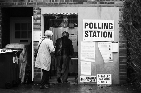 12月12日，在英国伦敦，两名老人到达一处投票站参加投票。新华社发